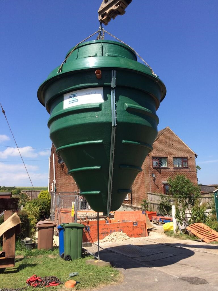 Green treatment tank being installed